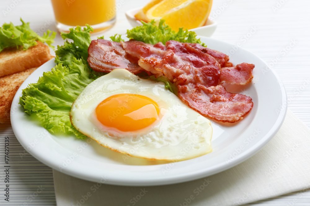 Bacon and eggs on color wooden table background Bacon and eggs on color wooden table background