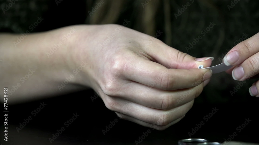 Detail shot of female hands making a smoking filter in slow motion Detail shot of female hands making a smoking filter in slow motion