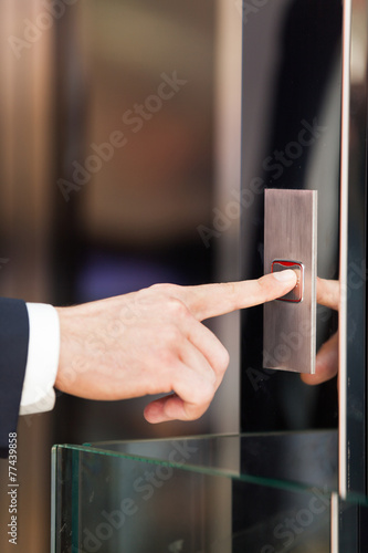 Man pressing red elevator button.