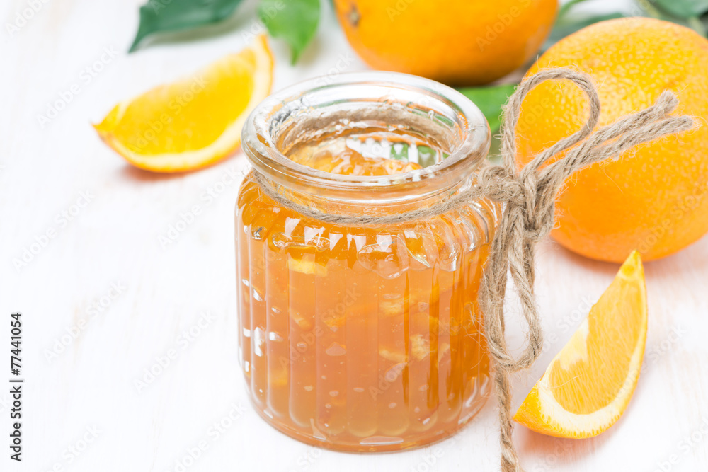 orange jam in a glass jar and oranges on the table orange jam in a glass jar and oranges on the table