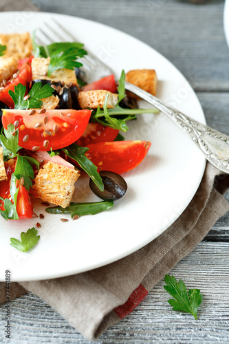  salad with tomatoes and croutons on a white plate