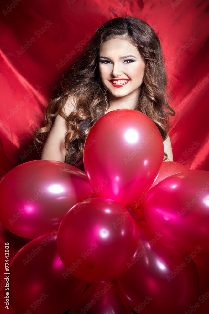happy young woman with red balls in hands