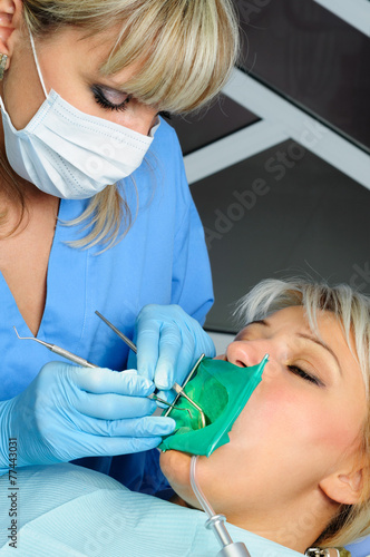 dentist with patient, cleaning and curing photo