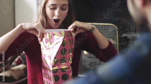 Young woman unwrapping gift 