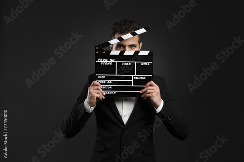 Business man holding a clapboard photo