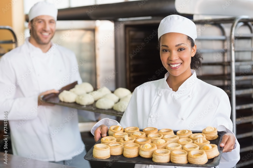 Baker smiling at the camera holding tray Baker smiling at the camera holding tray