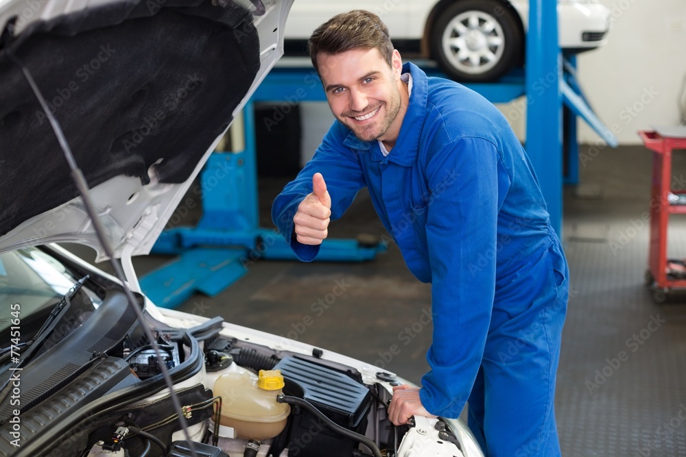 Mechanic examining under hood of car