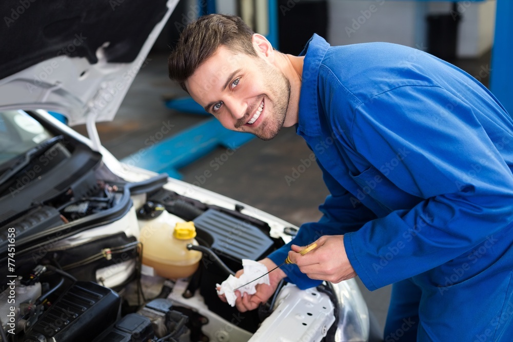 Mechanic testing oil in car Mechanic testing oil in car
