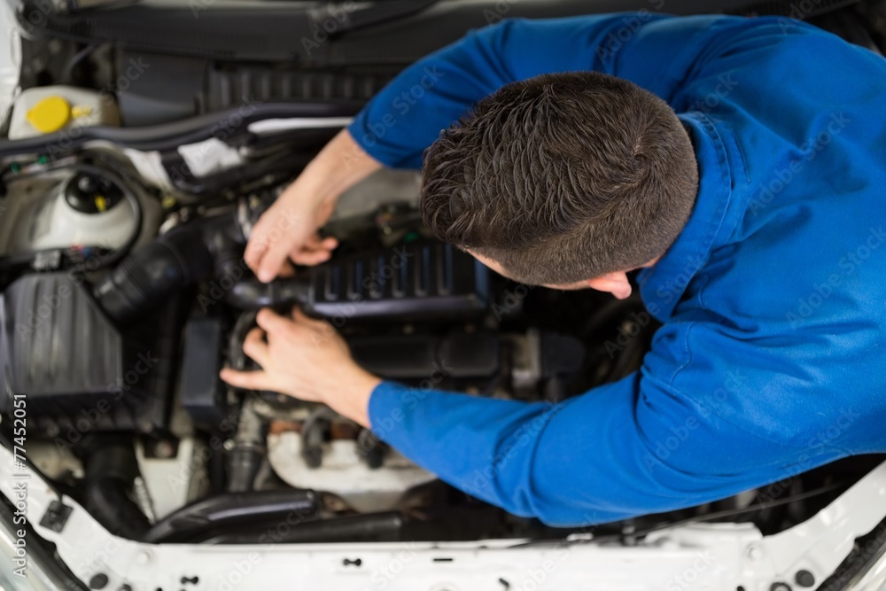 Mechanic examining under hood of car Mechanic examining under hood of car