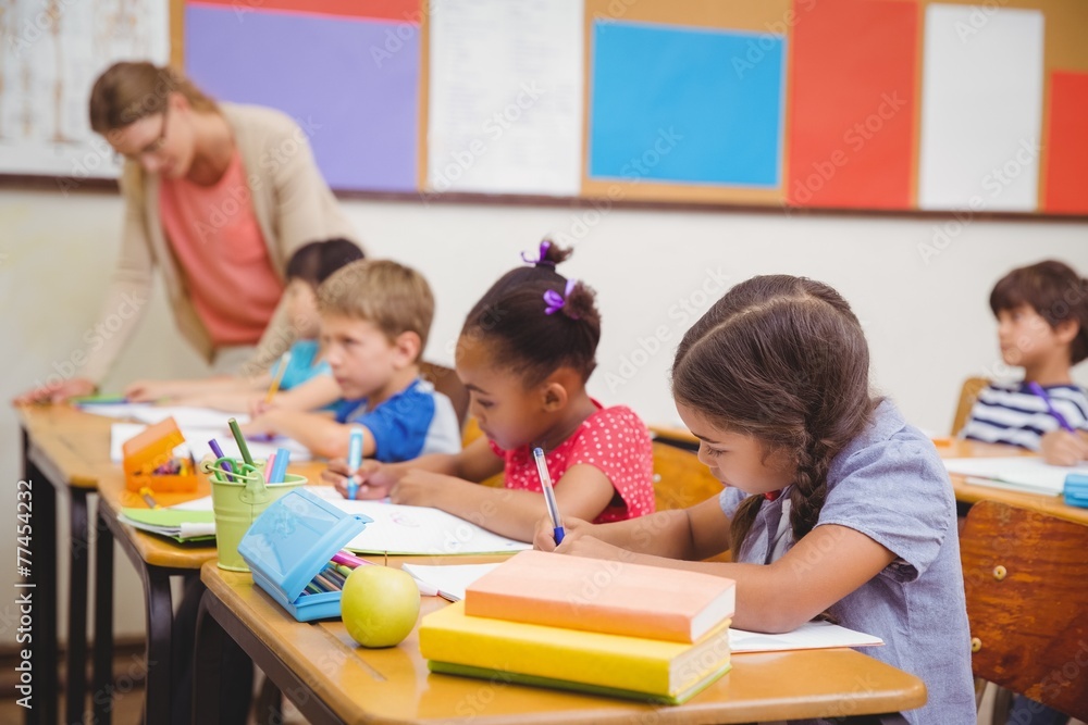 Cute pupils drawing at their desks Cute pupils drawing at their desks
