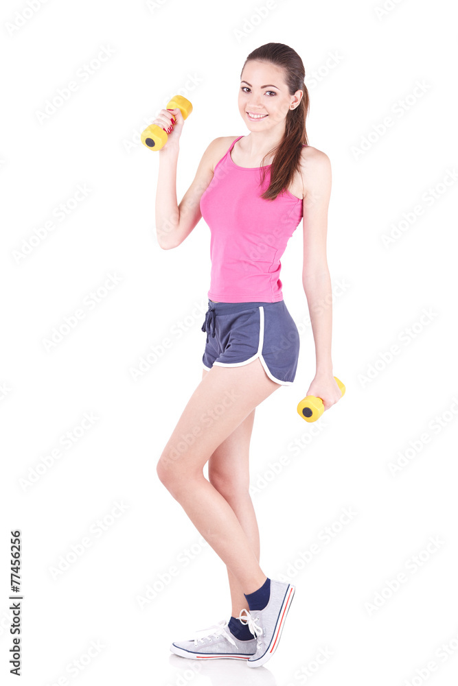 Young woman smiling while using dumbbells against a white backgr Young woman smiling while using dumbbells against a white backgr