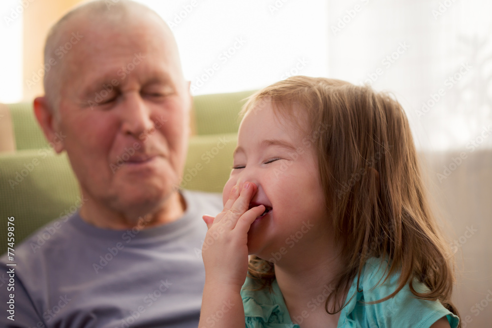 Cute little girl laughing with her grandfather Cute little girl laughing with her grandfather