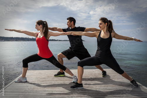 Group of people doing fitness facing the sea