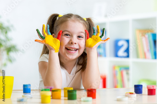 beautiful child girl with hands in color paints