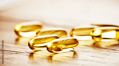 Fish oil omega 3 gel capsules  on wooden background