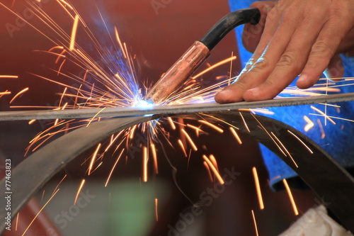 welder is welding steel flat bar without safety glove