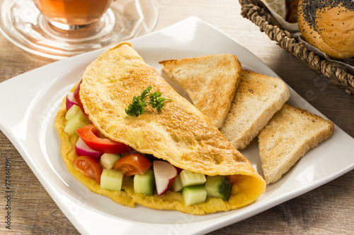 a nice omelet  with vegetables, on the table