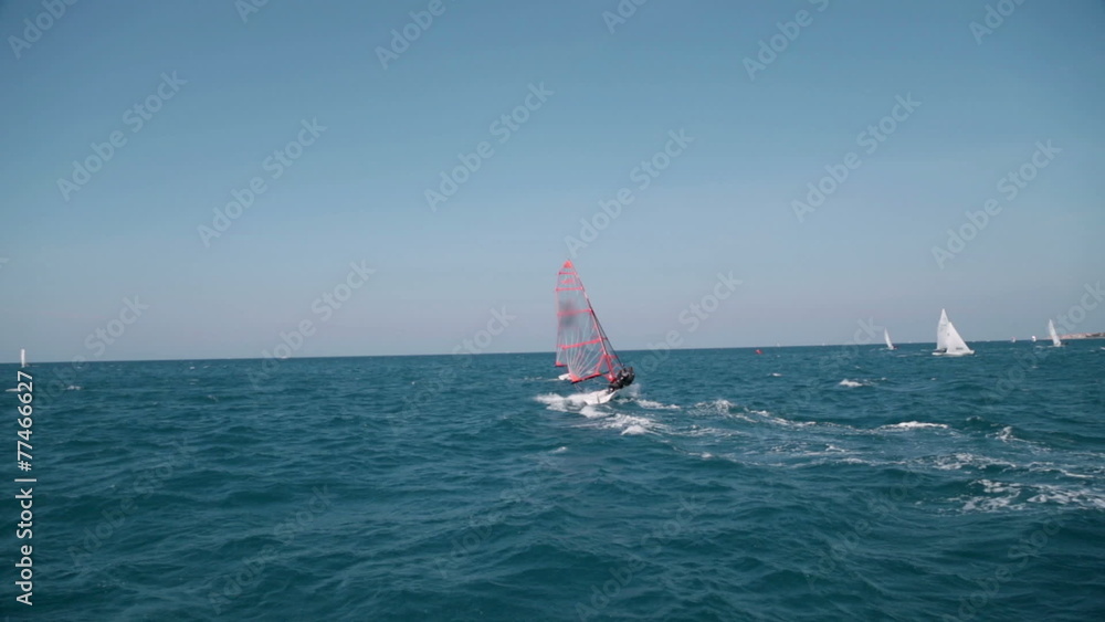 Small sailboat speeding around the sea at clear weather Small sailboat speeding around the sea at clear weather