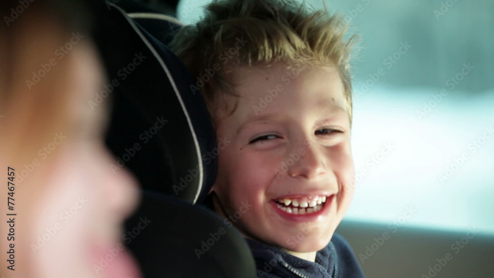two young, cheerful children who are having fun back in the car, while driving in a car to a certain destination two young, cheerful children who are having fun back in the car, while driving in a car to a certain destination