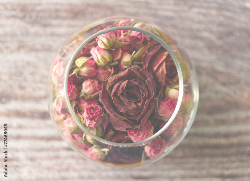 Romance composition with roses in a vase with wooden background