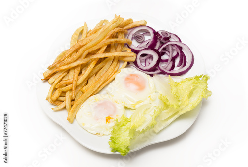 Uova e patatine fritte con contorno di cipolle rosse e lattuga