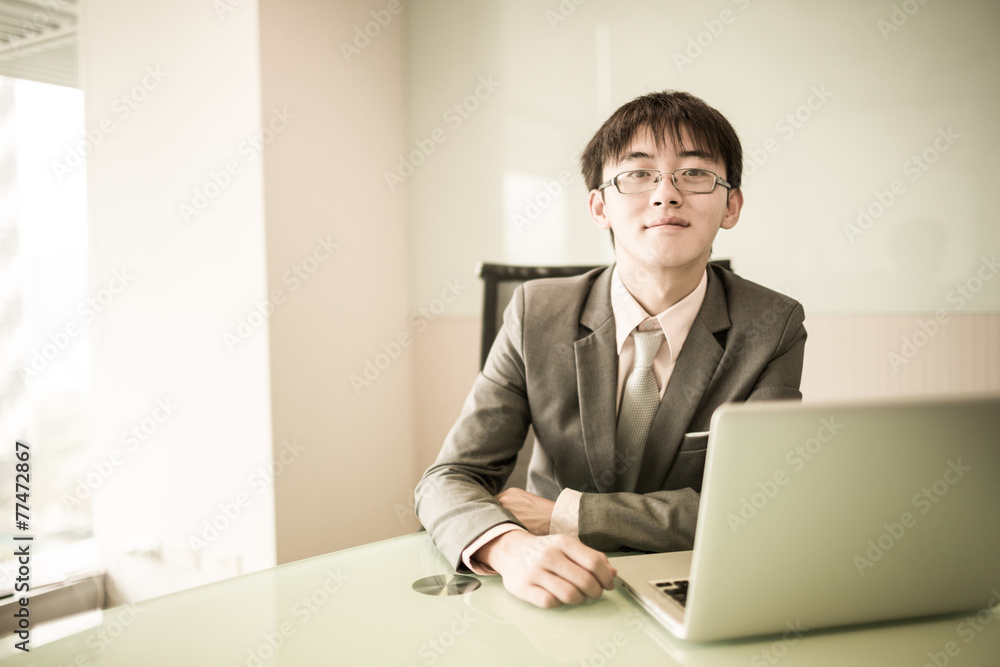 Young handsome man using laptop in his office Young handsome man using laptop in his office