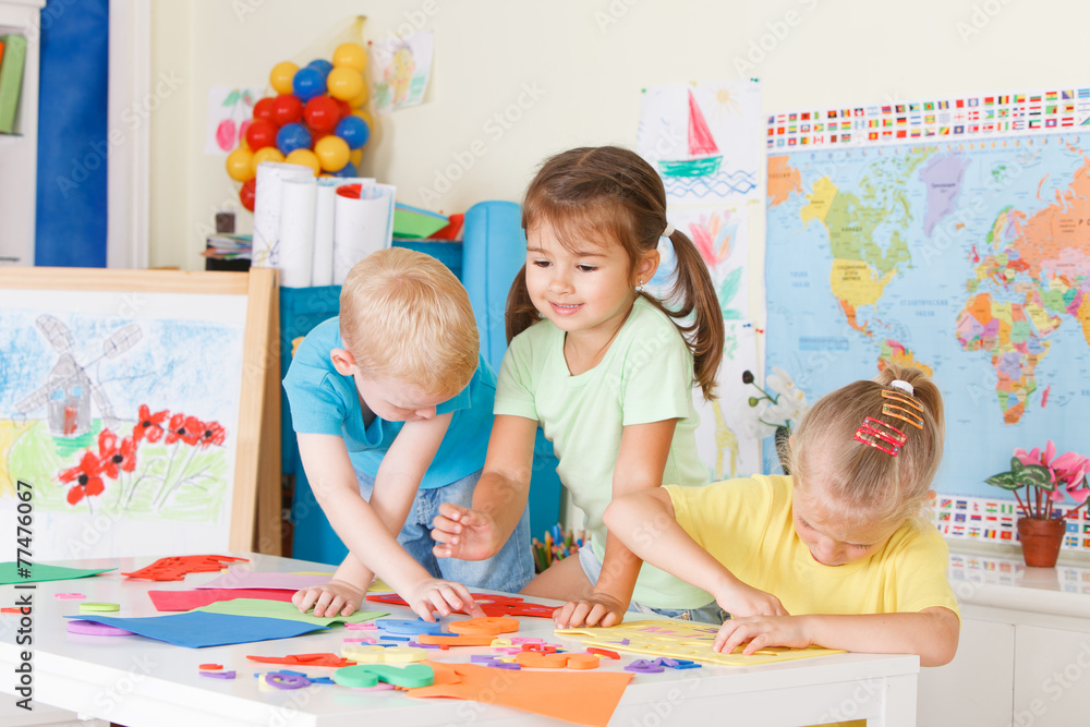 Fototapeta premium Three preschoolers in the classroom