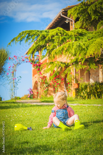 Marvelous little girl plays with on green spring grass