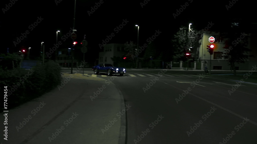 Car drives by at night in the city Car drives by at night in the city