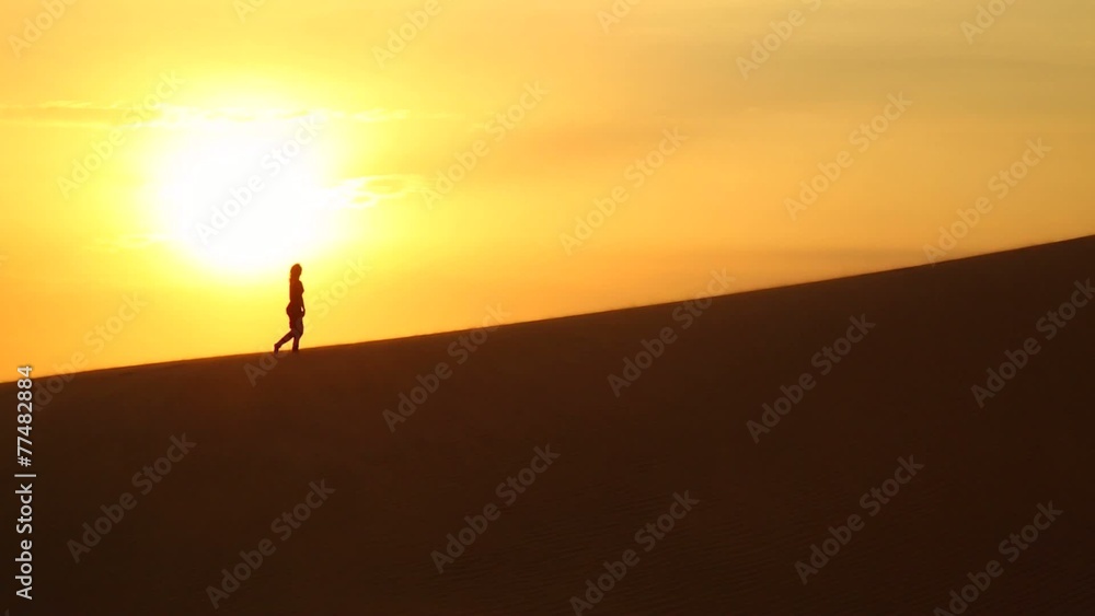 young girl climbs the hill in the desert at sunset young girl climbs the hill in the desert at sunset