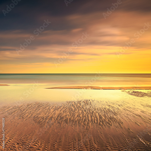 Ocean sandy beach line and warm sunset