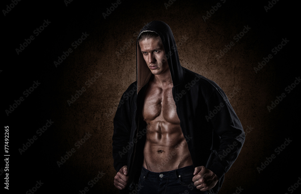 muscular sports man after weights training over black backgroun