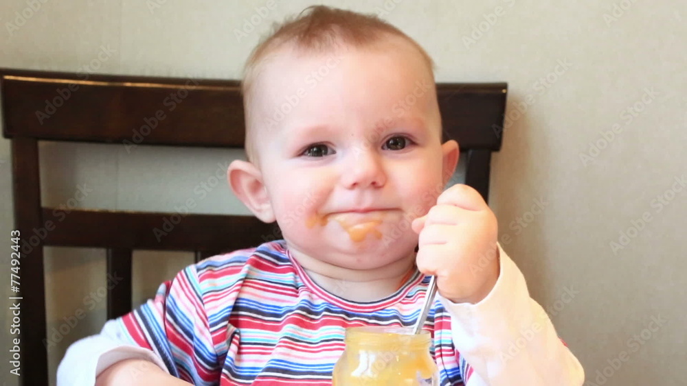 Little girl learns to eat with a spoon independently Little girl learns to eat with a spoon independently