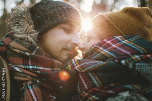 Young man hugs his girlfriend in winter forest