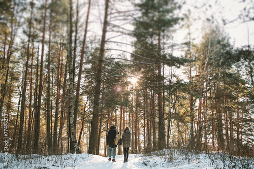 Young couple standing alone in winter forest