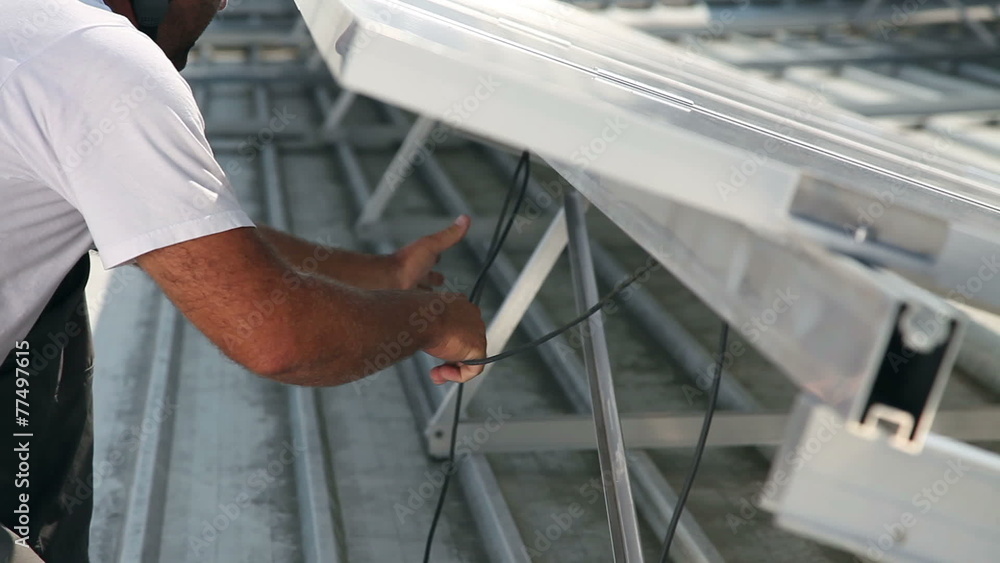 Man connecting wires of solar panels Man connecting wires of solar panels