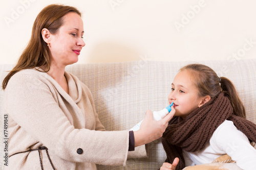 Woman treating daughter for rhinitis