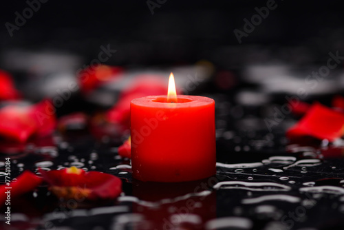 Red rose petals with candle and therapy stones