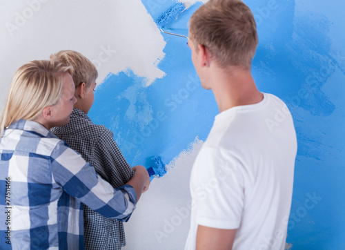 Little boy painting wall
