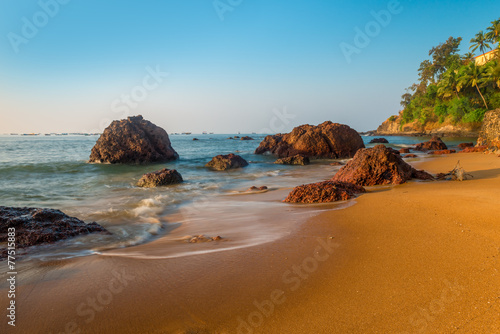 sandy beach and large boulders in the sea water