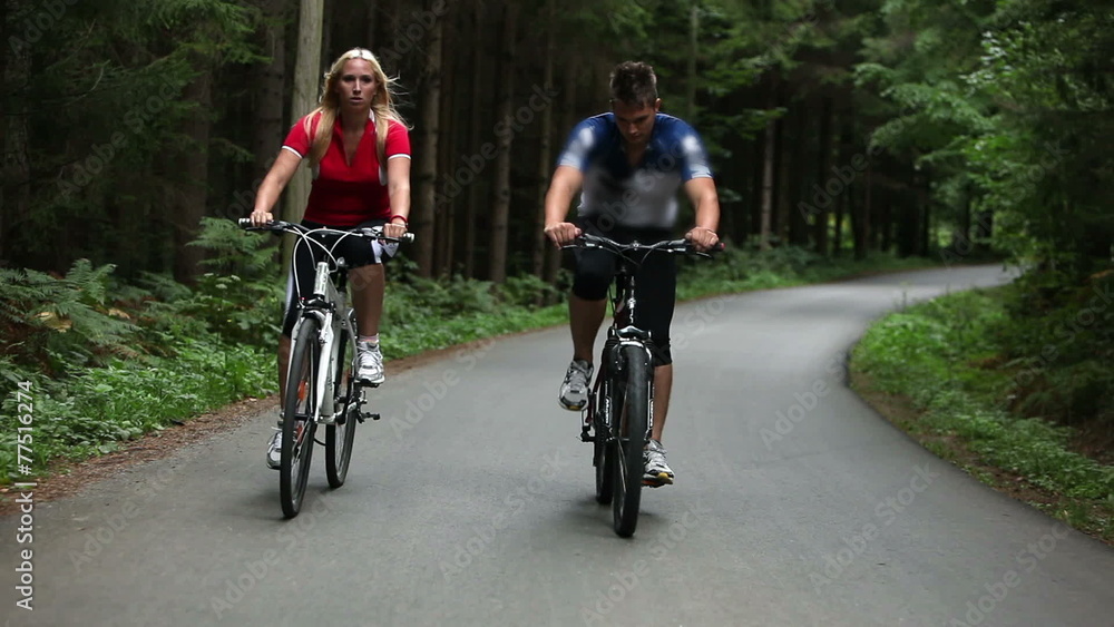 Total of young couple cycling in woods Total of young couple cycling in woods
