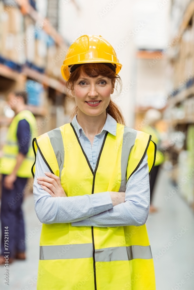 Warehouse manager smiling at camera with arms crossed Warehouse manager smiling at camera with arms crossed