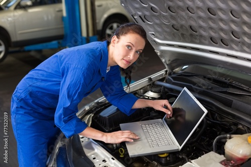 Mechanic using laptop on car