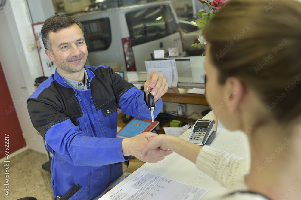 Obraz premium Mechanic giving keys back to car owner