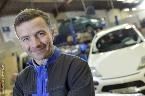 Portrait of smiling mechanic in auto repair shop