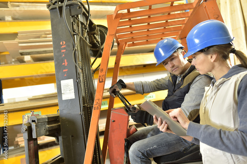 Operator with overseer working in warehouse
