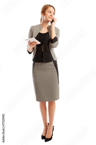 Confident business woman talking on the phone and holding tablet