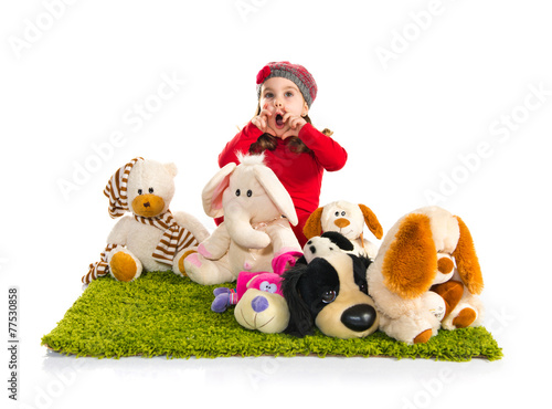 Surprised little girl playing with stuffed animals