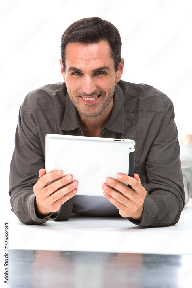 Man laying on the floor with digital tablet Man laying on the floor with digital tablet