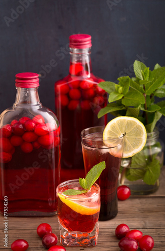 Shots and bottles of cranberry beverage